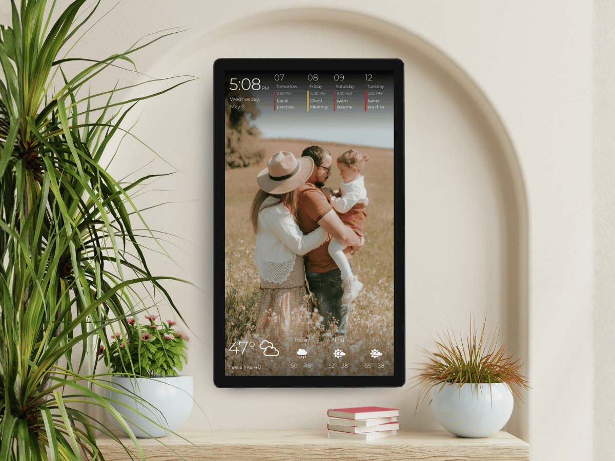 Digital photo frame mode A portrait DAKboard display in photo-frame mode shows a full-screen family photo with upcoming calendar events across the top and a weather forecast below