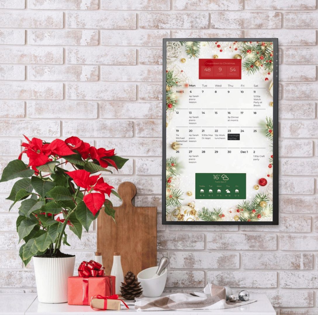 Premium framed wall display Premium pre-framed DAKboard wall display in portrait orientation showing a festive holiday family calendar and weather forecast