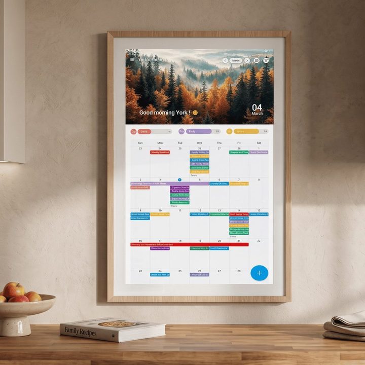 ApoloSign touchscreen calendar display on a wall showing a monthly family schedule grid