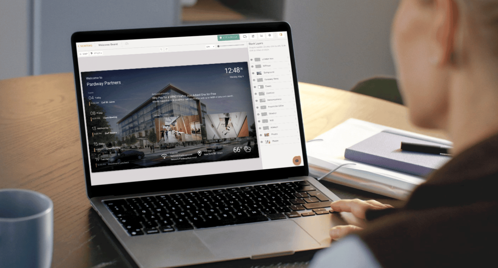 Remote screen management Host editing a DAKboard welcome screen remotely on a laptop, styling the layout and fonts to match a vacation rental property